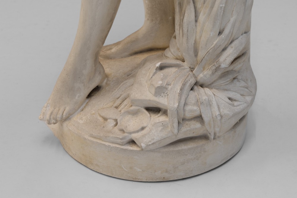 An off-white Neoclassical standing female bather sculpture draped in cloth on a circular base. View VII