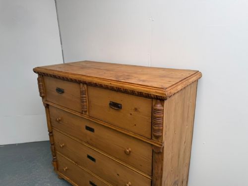 fig 1. A large antique waxed pine chest of drawers featuring two small upper drawers over three full-width drawers with turned side columns.