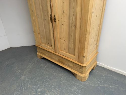 fig 2. An early Georgian pine knockdown wardrobe with a prominent moulded cornice, two flat-panelled doors, and a sturdy plinth base.