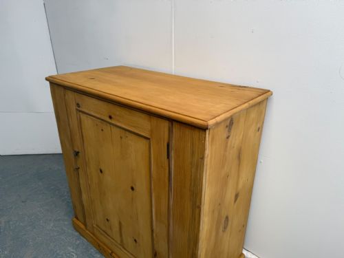 fig 1. A Victorian waxed pine single-door hall cupboard featuring a panelled door, flat top surface, and plinth base.