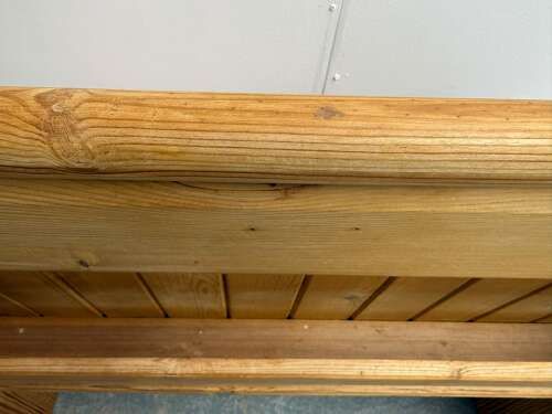 fig 1. A small Victorian waxed pine church pew featuring a panelled backrest, shaped end supports, and a lower rail.