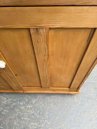 fig 1. A Victorian waxed pine dresser base featuring two top drawers and two panelled cupboard doors with turned wooden knobs.