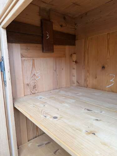 fig 2. A tall natural pine Victorian knockdown wardrobe featuring two panelled doors, fluted side pilasters, two base drawers, and turned bun feet.