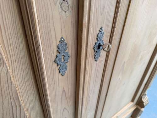 fig 1. A double-door Victorian stripped pine wardrobe featuring carved corbels, moulded door panels, and turned bun feet.