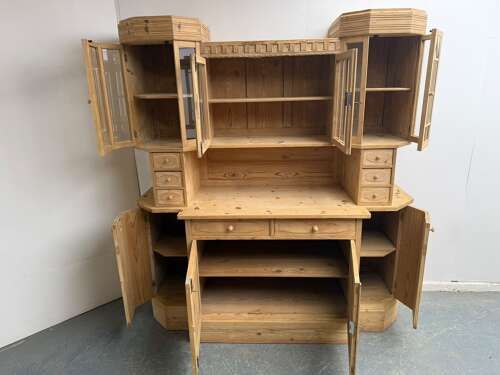 fig 1. An antique two-piece stripped pine kitchen dresser featuring upper glazed cabinets with geometric tracery, small drawers, and a lower cabinet base.