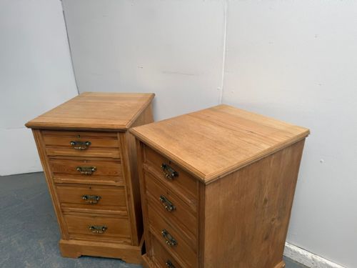 fig 1. A pair of Arts and Crafts waxed ash bedside cabinets featuring four stacked drawers each with decorative brass drop handles.