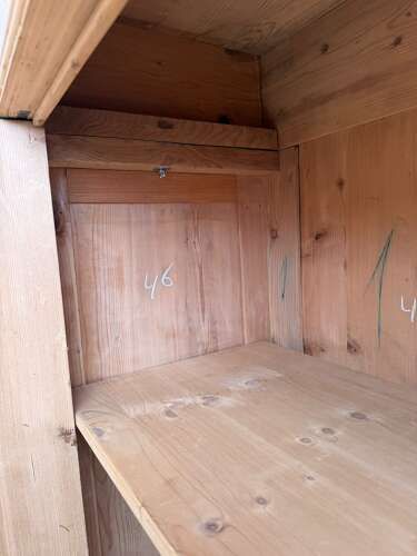 fig 1. A tall stripped pine double-door cupboard featuring a moulded top cornice, panelled doors, and turned bun feet.