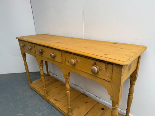 fig 1. A long Georgian antique pine pot board server featuring three drawers with turned wooden handles, shaped aprons, turned legs, and an open lower shelf.