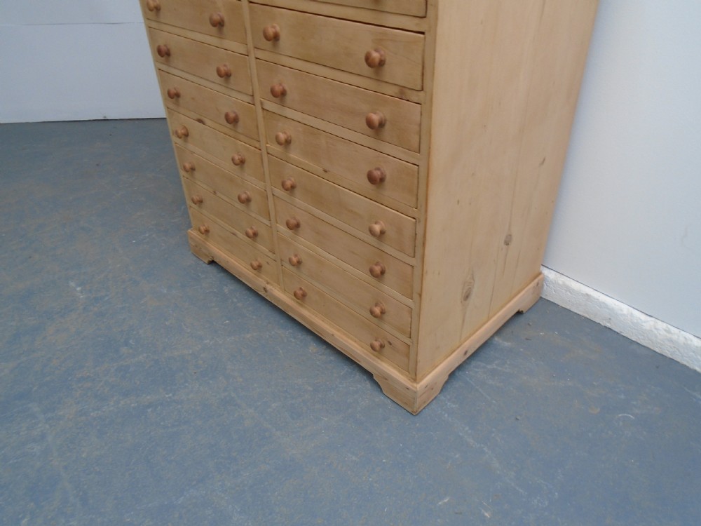 A tall Victorian pine collectors chest featuring two side-by-side columns of shallow drawers with turned wooden knob handles. View III