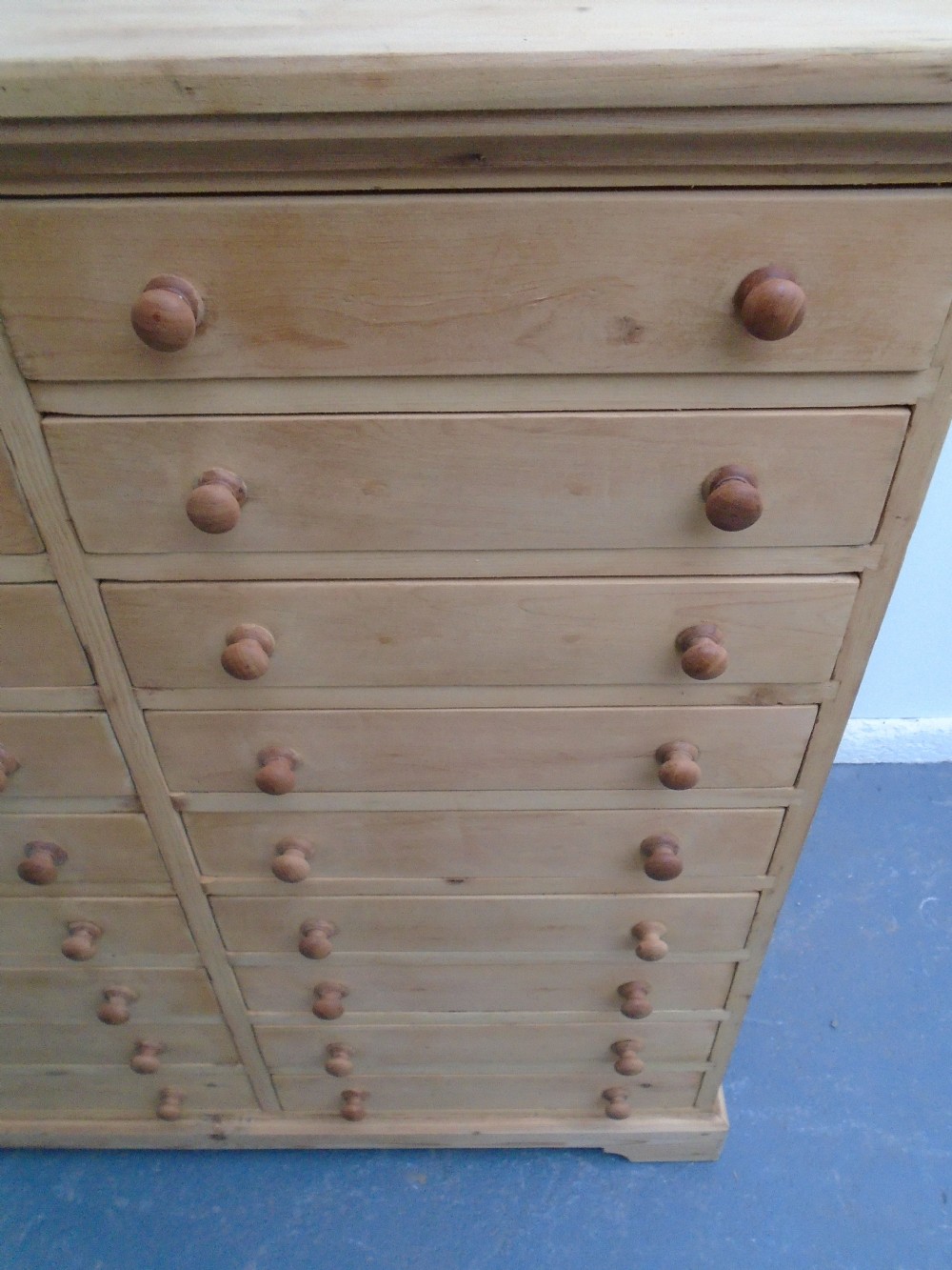 A tall Victorian pine collectors chest featuring two side-by-side columns of shallow drawers with turned wooden knob handles. View IX