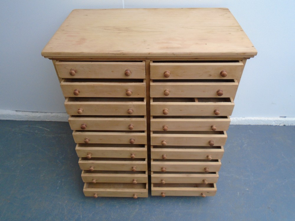A tall Victorian pine collectors chest featuring two side-by-side columns of shallow drawers with turned wooden knob handles. View X