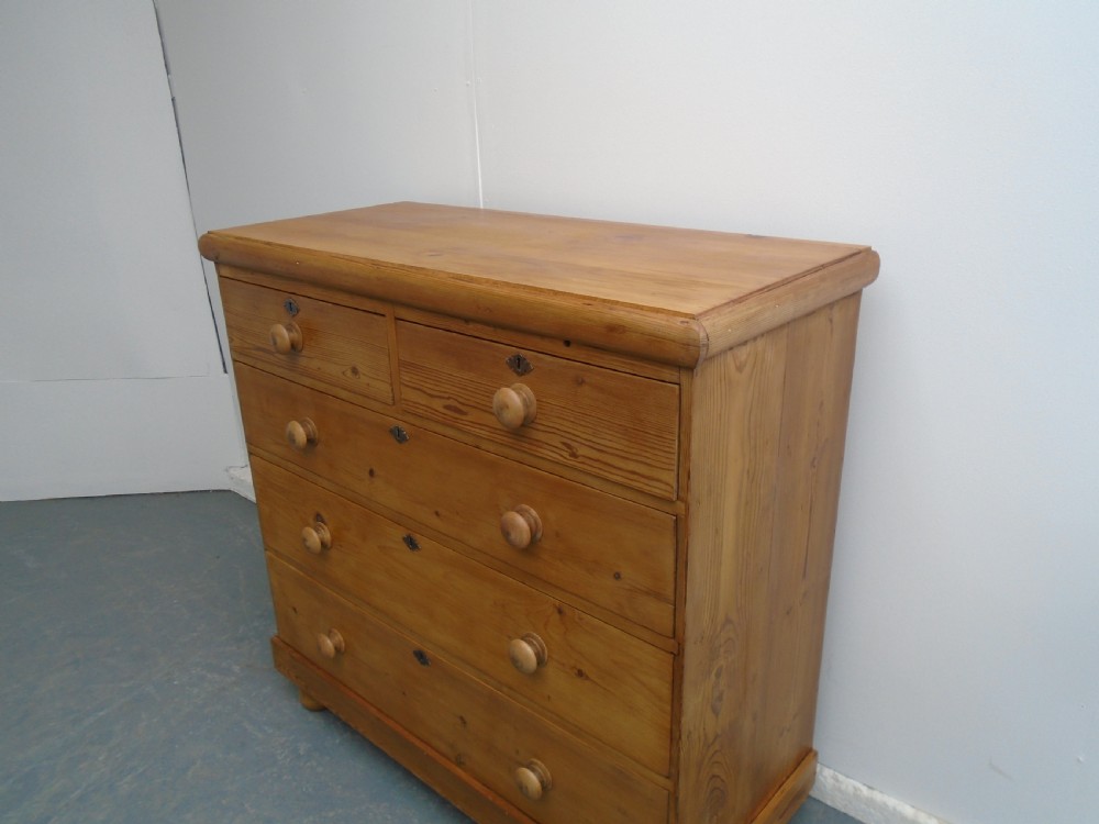 A Victorian waxed pine chest featuring two short over three long graduating drawers with turned wooden knobs. View II