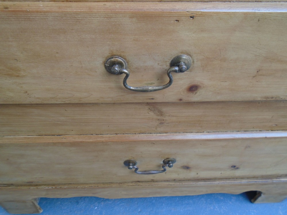 An extra wide Georgian waxed pine blanket box featuring a hinged top lid, brass swan-neck handles, faux drawer fronts, and a bracket base. View III