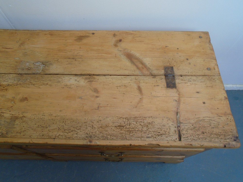 An extra wide Georgian waxed pine blanket box featuring a hinged top lid, brass swan-neck handles, faux drawer fronts, and a bracket base. View VIII