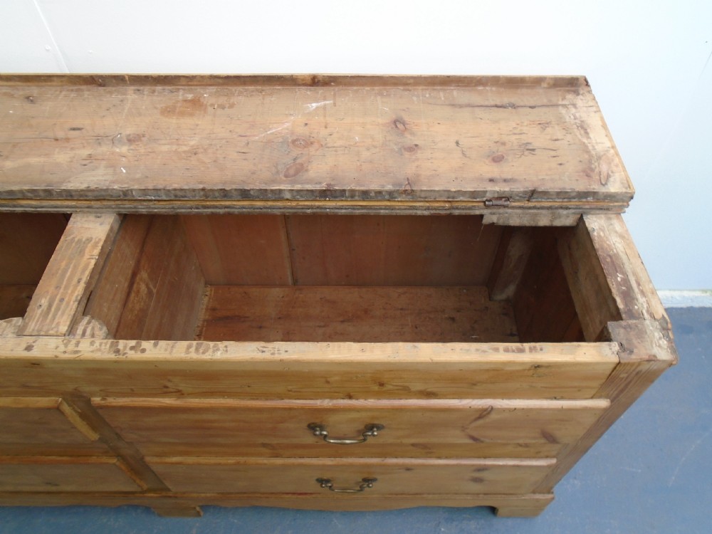 An extra wide Georgian waxed pine blanket box featuring a hinged top lid, brass swan-neck handles, faux drawer fronts, and a bracket base. View XI