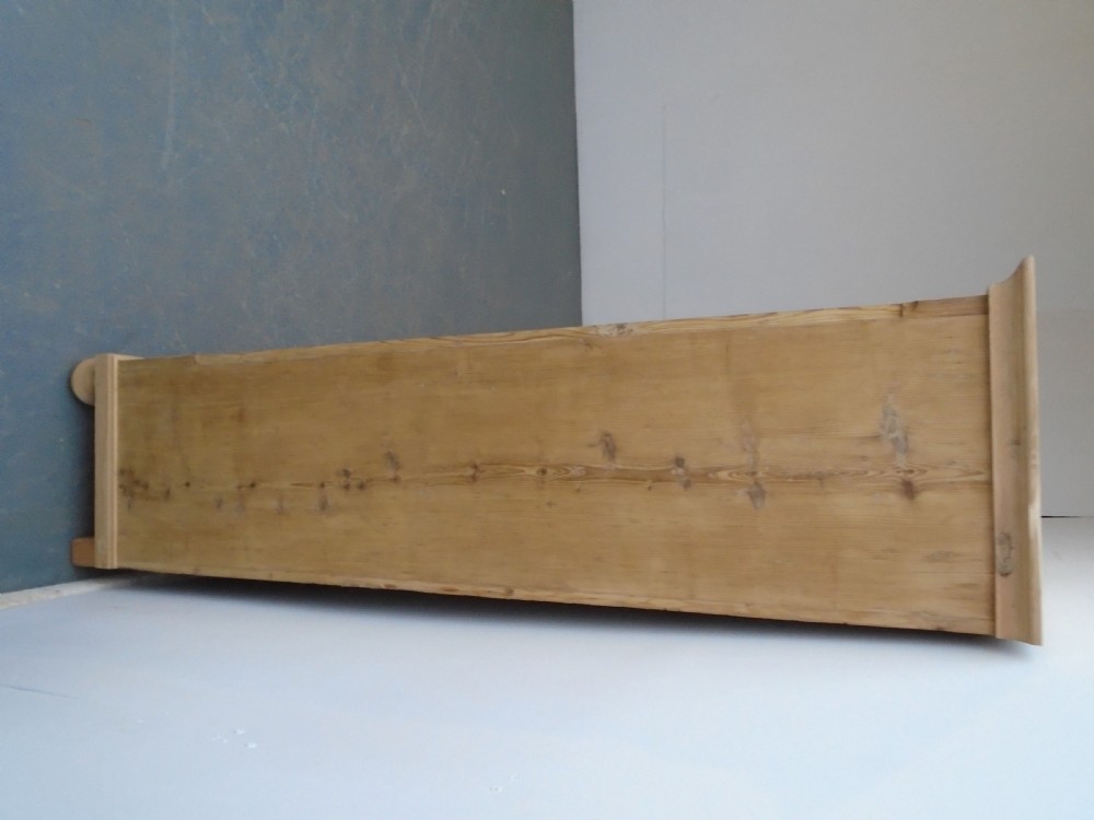 A tall Georgian natural pine storage cupboard featuring two fielded panel doors above a wide base drawer, set on turned bun feet. View V