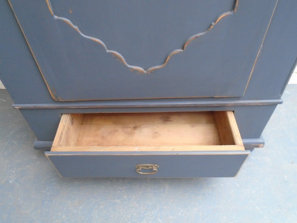 A tall Georgian painted pine cupboard in slate grey featuring a single panelled door with a scalloped insert and a lower drawer. View VIII