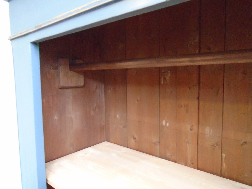 A tall Georgian painted pine cupboard in slate grey featuring a single panelled door with a scalloped insert and a lower drawer. View XI