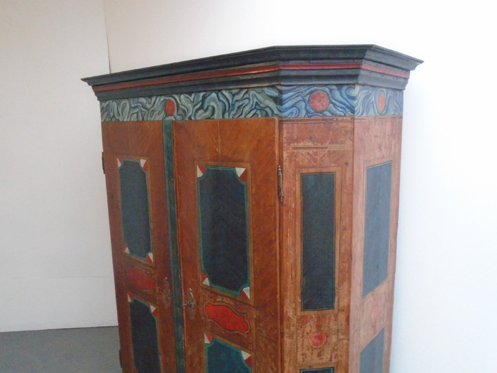 An antique Swedish painted pine two-door wardrobe featuring folk art geometric panels in teal green, red, and faux-grain wood finish. View II