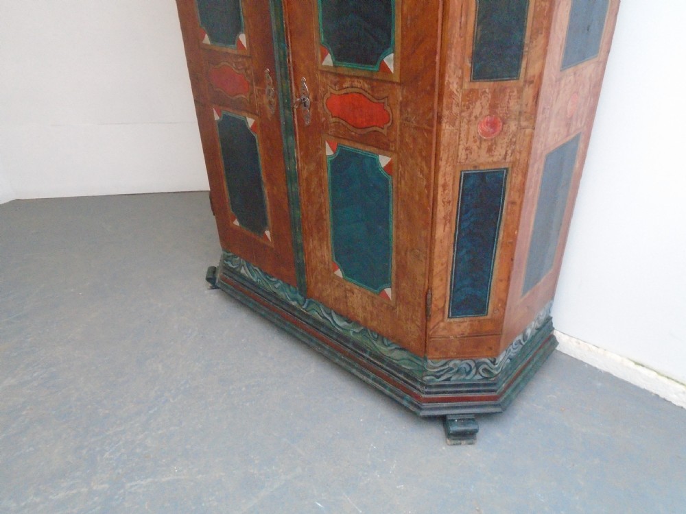 An antique Swedish painted pine two-door wardrobe featuring folk art geometric panels in teal green, red, and faux-grain wood finish. View III