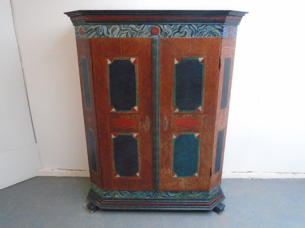 An antique Swedish painted pine two-door wardrobe featuring folk art geometric panels in teal green, red, and faux-grain wood finish. View IV