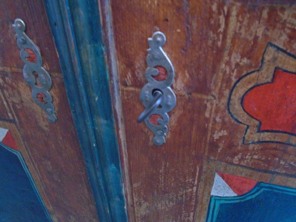 An antique Swedish painted pine two-door wardrobe featuring folk art geometric panels in teal green, red, and faux-grain wood finish. View XI