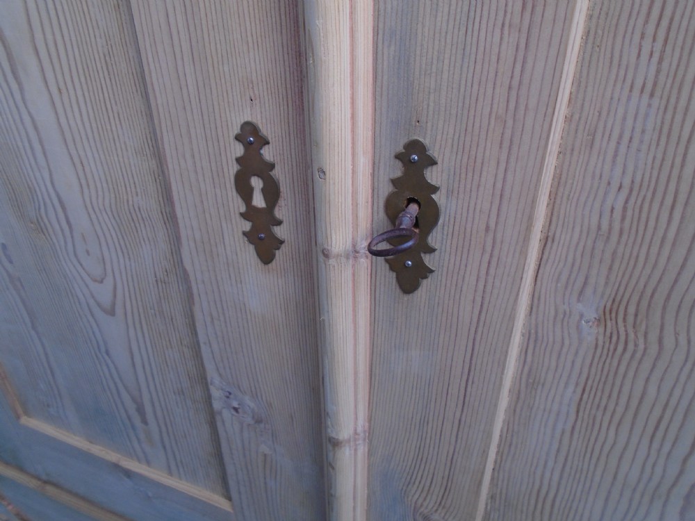 An unpainted Georgian pine two-door wardrobe featuring recessed panel doors, side panel construction, and a prominent moulded upper cornice. View VI