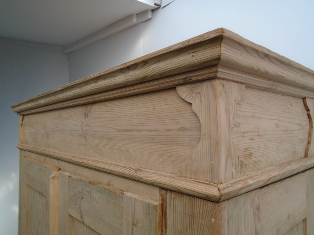 An unpainted Georgian pine two-door wardrobe featuring recessed panel doors, side panel construction, and a prominent moulded upper cornice. View IX
