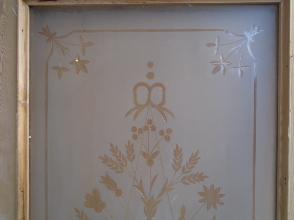 A Victorian stripped pine interior door featuring a large top panel of frosted glass etched with a central urn floral motif above two raised timber panels. View VI