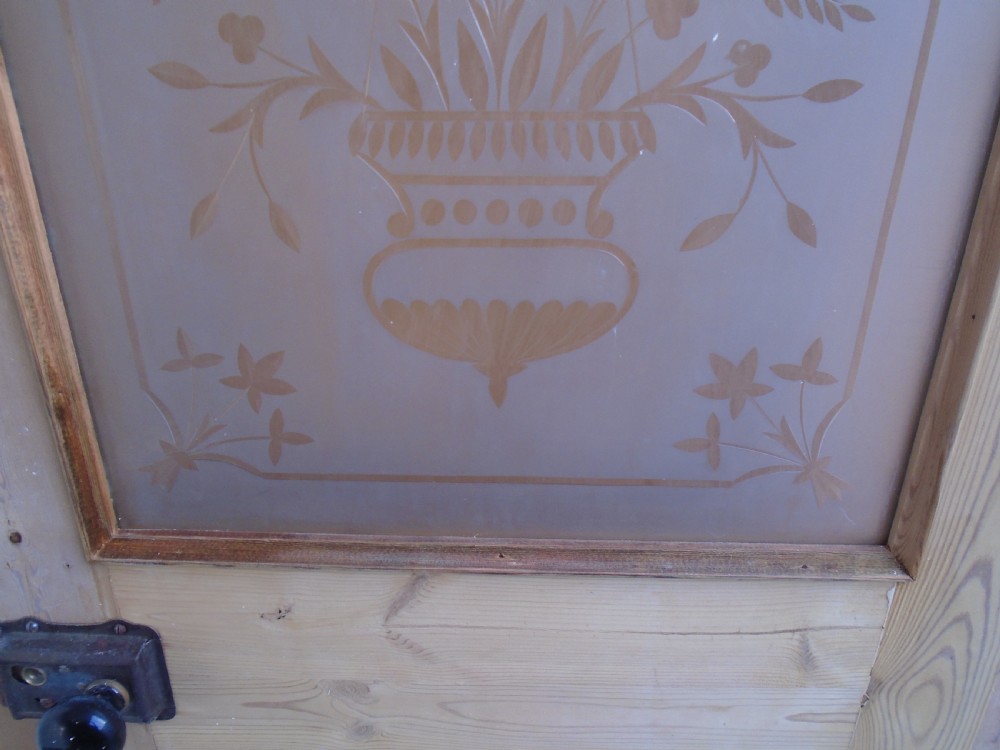 A Victorian stripped pine interior door featuring a large top panel of frosted glass etched with a central urn floral motif above two raised timber panels. View VIII