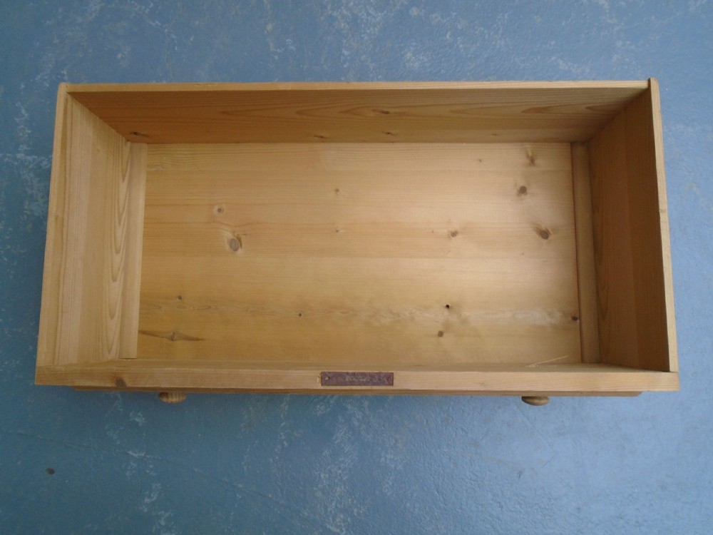 A tall Victorian stripped pine chest featuring five drawers, turned side columns, wooden knobs, and brass escutcheons. View XII