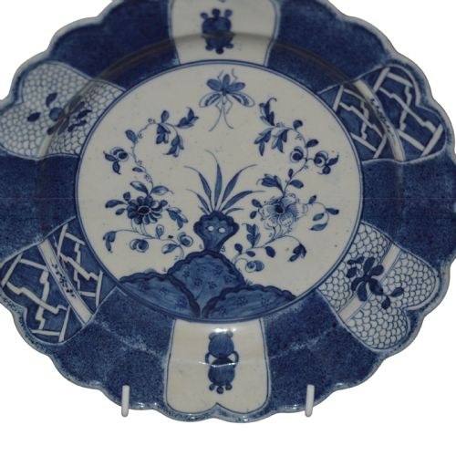 fig 1. A circular eighteenth-century Caughley porcelain dessert dish featuring a scalloped rim, underglaze cobalt blue Scholars Rock motif, and panelled diaper borders.