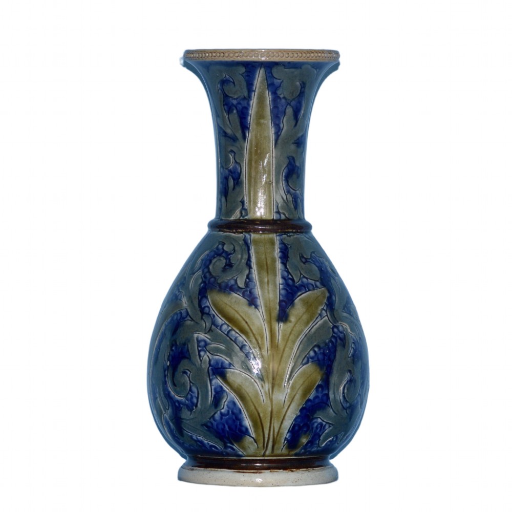 An antique Doulton Lambeth salt-glazed stoneware vase featuring incised blue and olive green foliate scrolling motifs, a flared neck, and a beaded rim.