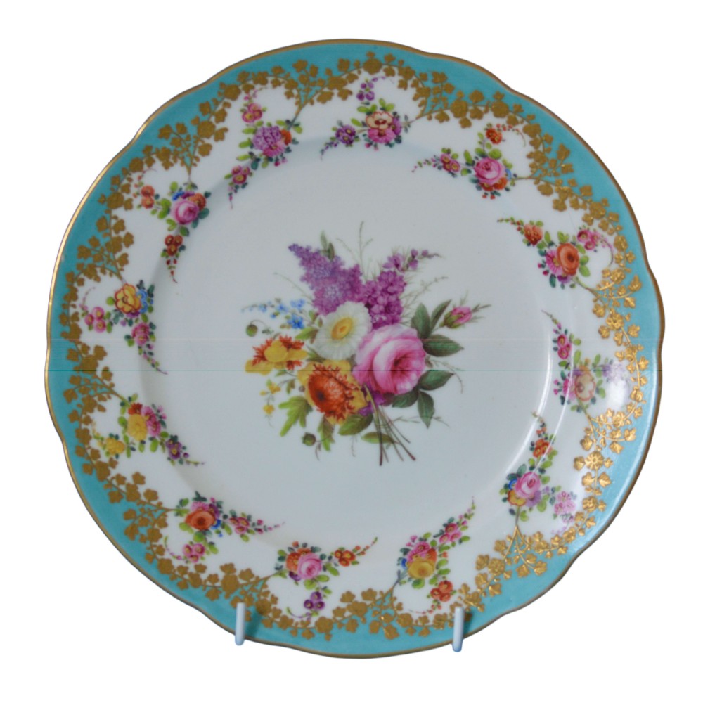 A circular Regency porcelain cabinet plate featuring a turquoise border with gilded foliage and a central hand-painted floral bouquet on a white ground.