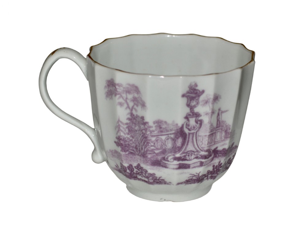 A white fluted porcelain coffee cup decorated with a purple transfer-printed scene of a seated couple in a garden setting, featuring a single loop handle and gilded rim. View II