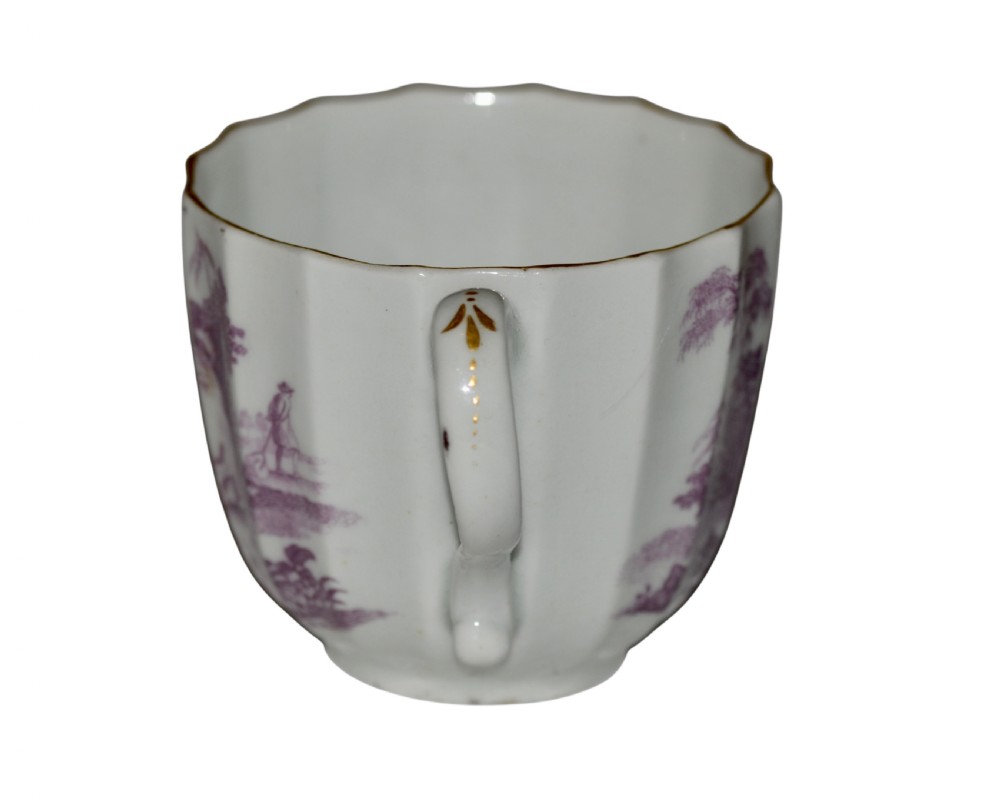 A white fluted porcelain coffee cup decorated with a purple transfer-printed scene of a seated couple in a garden setting, featuring a single loop handle and gilded rim. View III