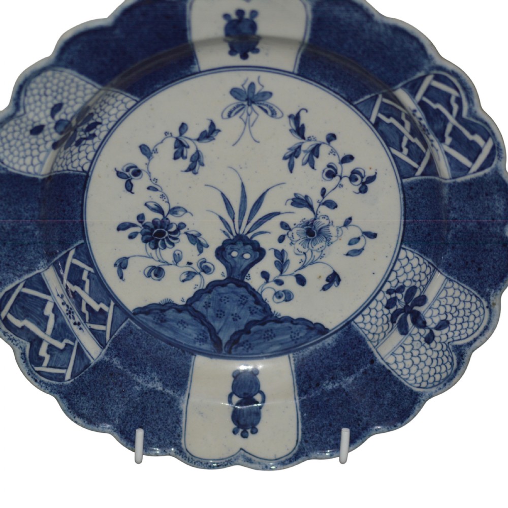 A circular eighteenth-century Caughley porcelain dessert dish featuring a scalloped rim, underglaze cobalt blue Scholars Rock motif, and panelled diaper borders. View II