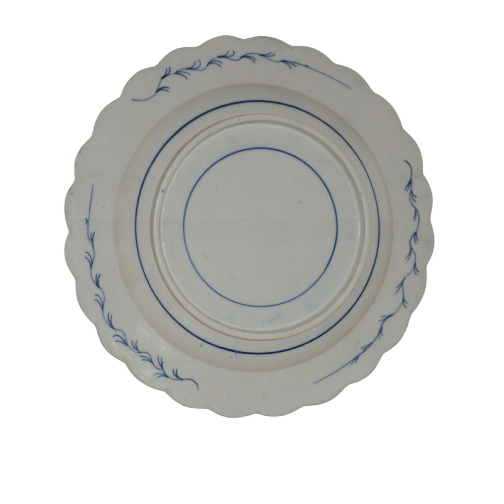 A circular eighteenth-century Caughley porcelain dessert dish featuring a scalloped rim, underglaze cobalt blue Scholars Rock motif, and panelled diaper borders. View III
