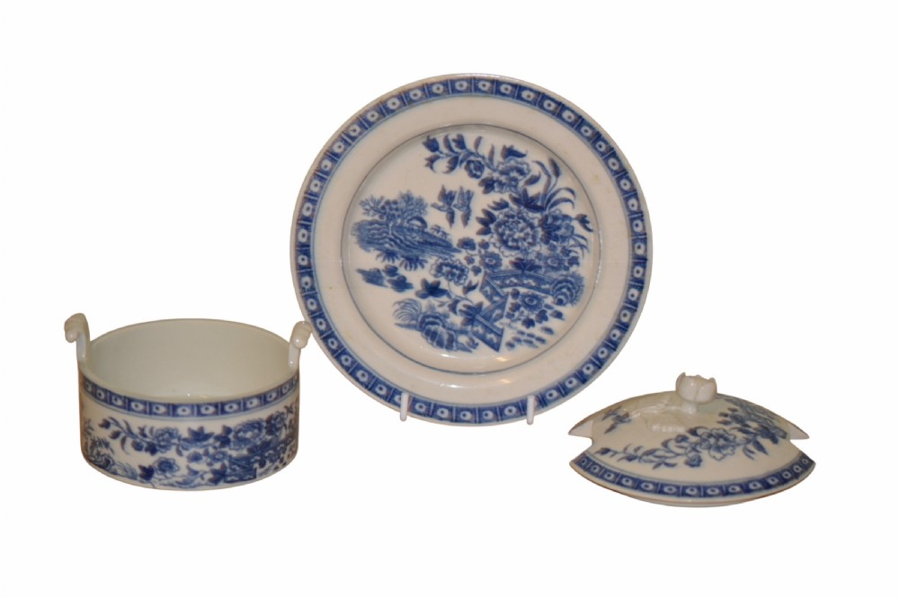 An 18th-century Dr Wall Worcester blue and white porcelain butter tub with a lid featuring a sculpted flower finial, resting on a matching oval stand. View V