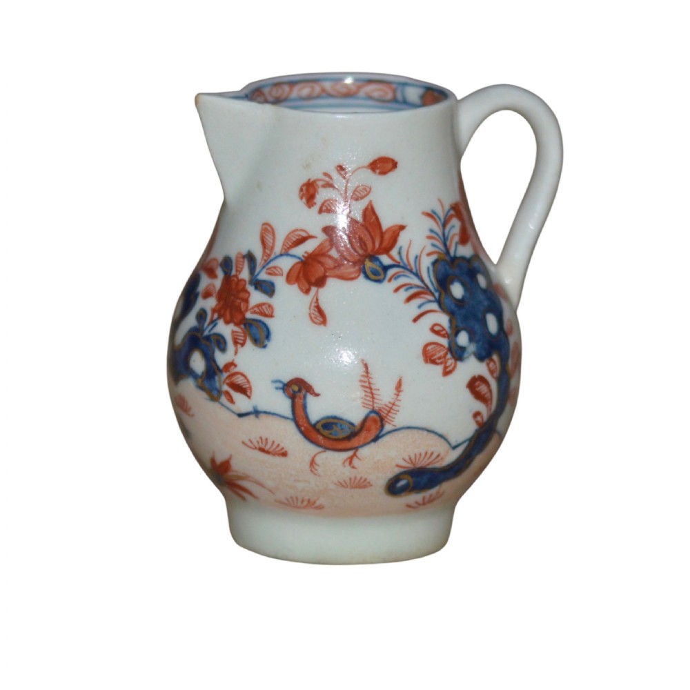 An 18th-century Lowestoft soft-paste porcelain sparrow-beak jug featuring hand-painted red and blue foliage and bird motifs.