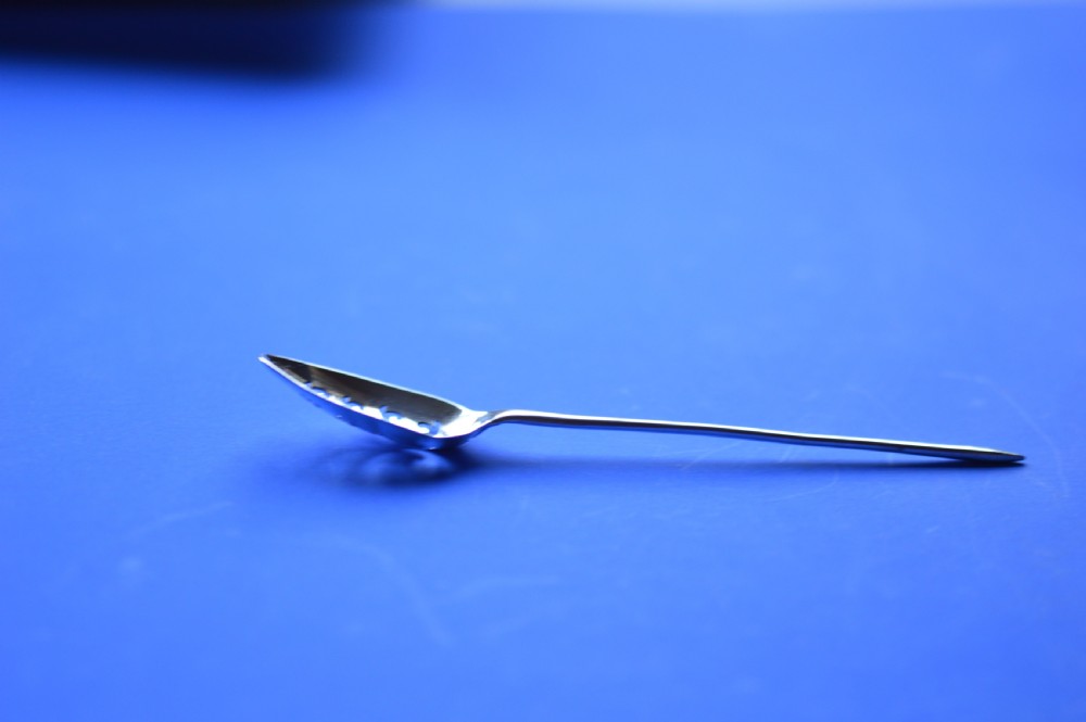 An 18th-century silver mote spoon featuring a hand-pierced oval bowl and a long tapered stem ending in a sharp point. View VIII