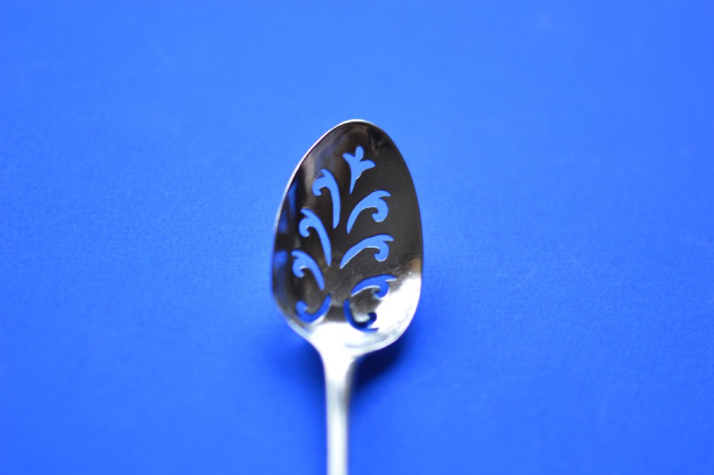 An 18th-century silver mote spoon featuring a hand-pierced oval bowl and a long tapered stem ending in a sharp point. View IX