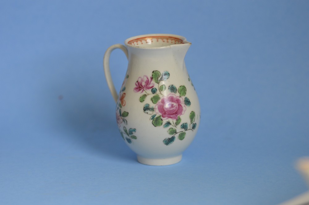 An 18th-century soft-paste porcelain sparrow beak cream jug with hand-painted pink and orange floral sprigs on a white ground. View II