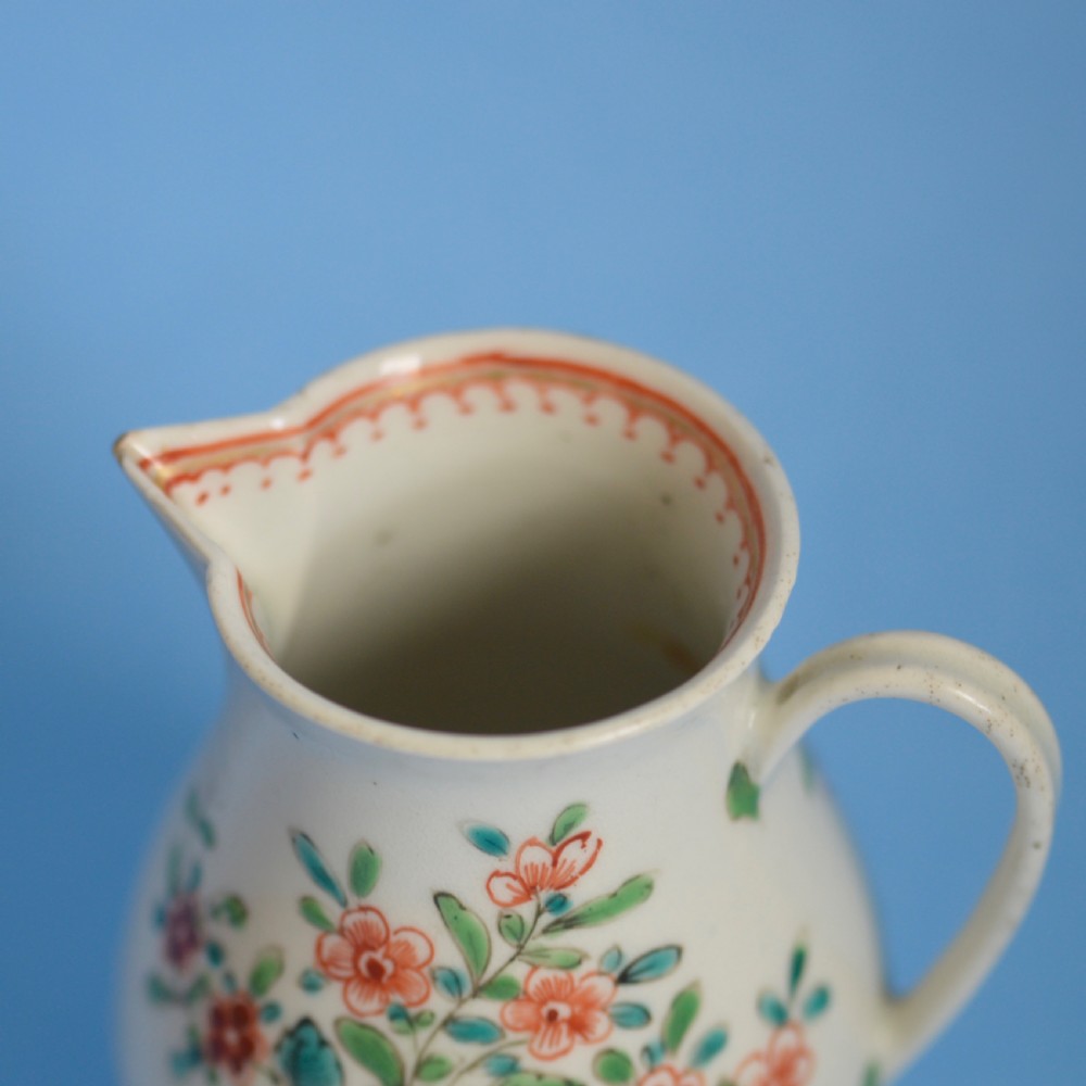 An 18th-century soft-paste porcelain sparrow beak cream jug with hand-painted pink and orange floral sprigs on a white ground. View V