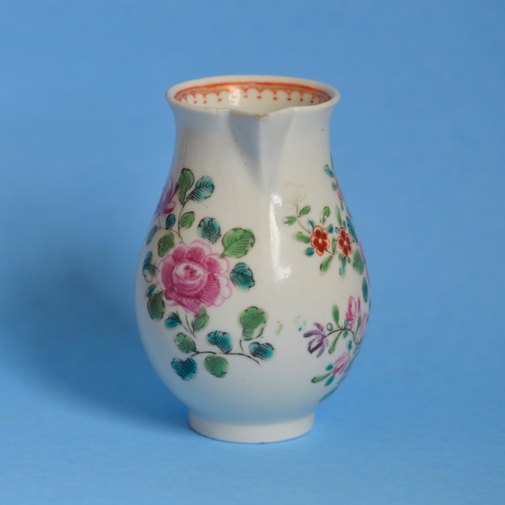 An 18th-century soft-paste porcelain sparrow beak cream jug with hand-painted pink and orange floral sprigs on a white ground. View IX