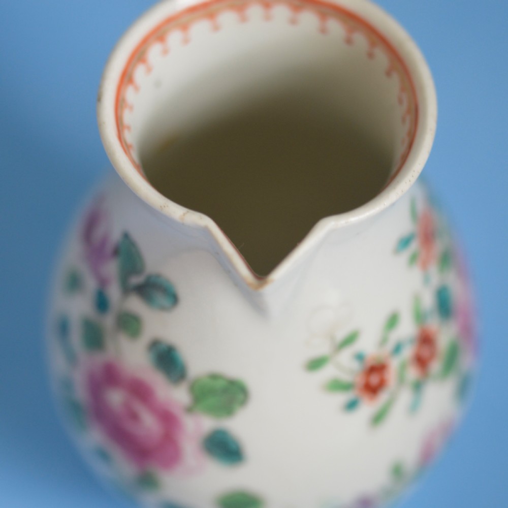 An 18th-century soft-paste porcelain sparrow beak cream jug with hand-painted pink and orange floral sprigs on a white ground. View XI