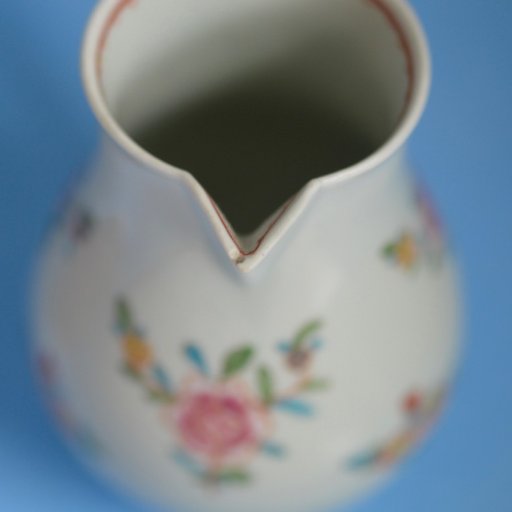 An 18th-century soft-paste porcelain sparrow beak cream jug with hand-painted pink and orange floral sprigs on a white ground. View XII