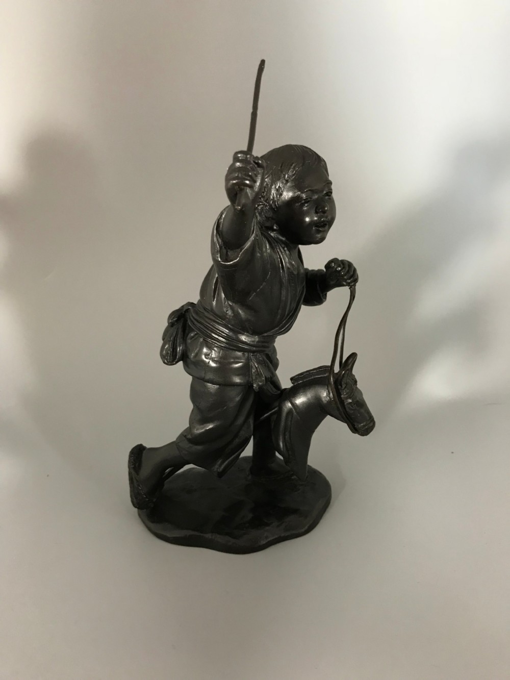 BRONZE OKIMONO OF BOY ON HOBBY HORSE  View II