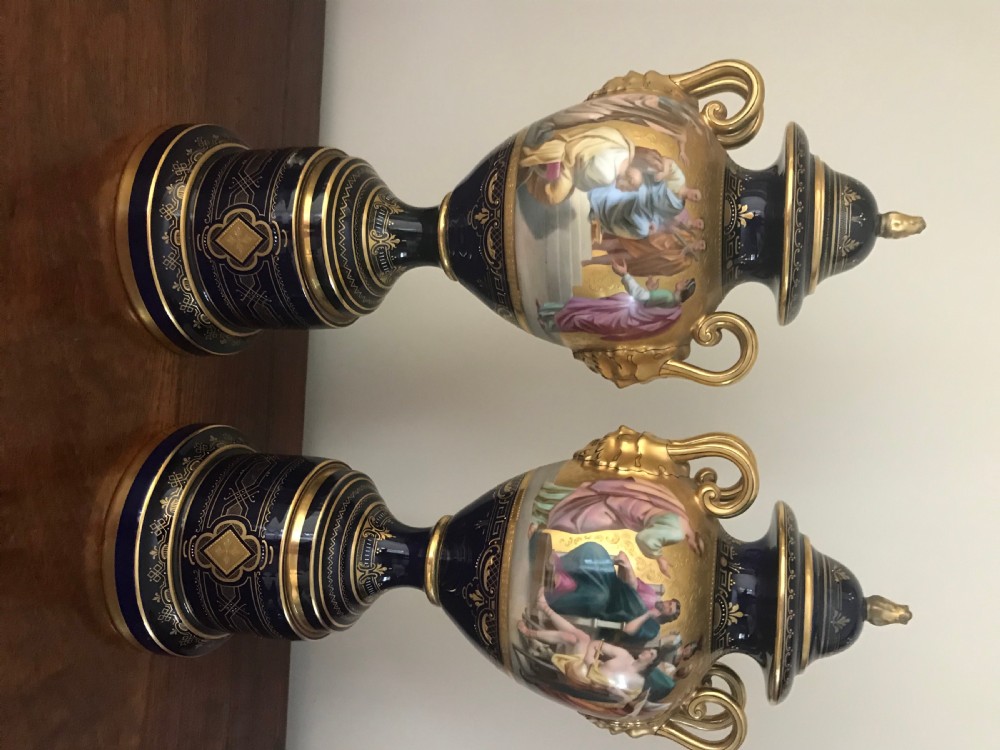 A pair of cobalt blue and gilded Vienna porcelain urns with hand-painted classical mythological figure panels and matching bases. View IV