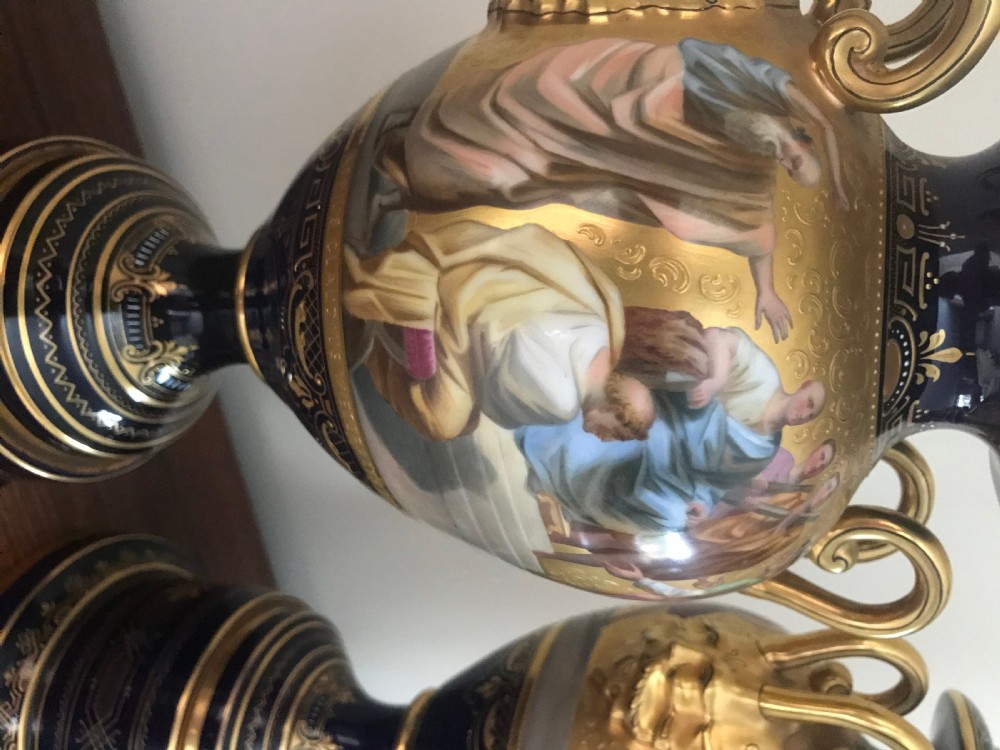 A pair of cobalt blue and gilded Vienna porcelain urns with hand-painted classical mythological figure panels and matching bases. View VIII